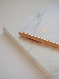 Minimalist marble journal with a gold pen, perfect for elegant stationery and writing inspiration.