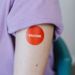 A person's arm with a red vaccine sticker, symbolizing vaccination.